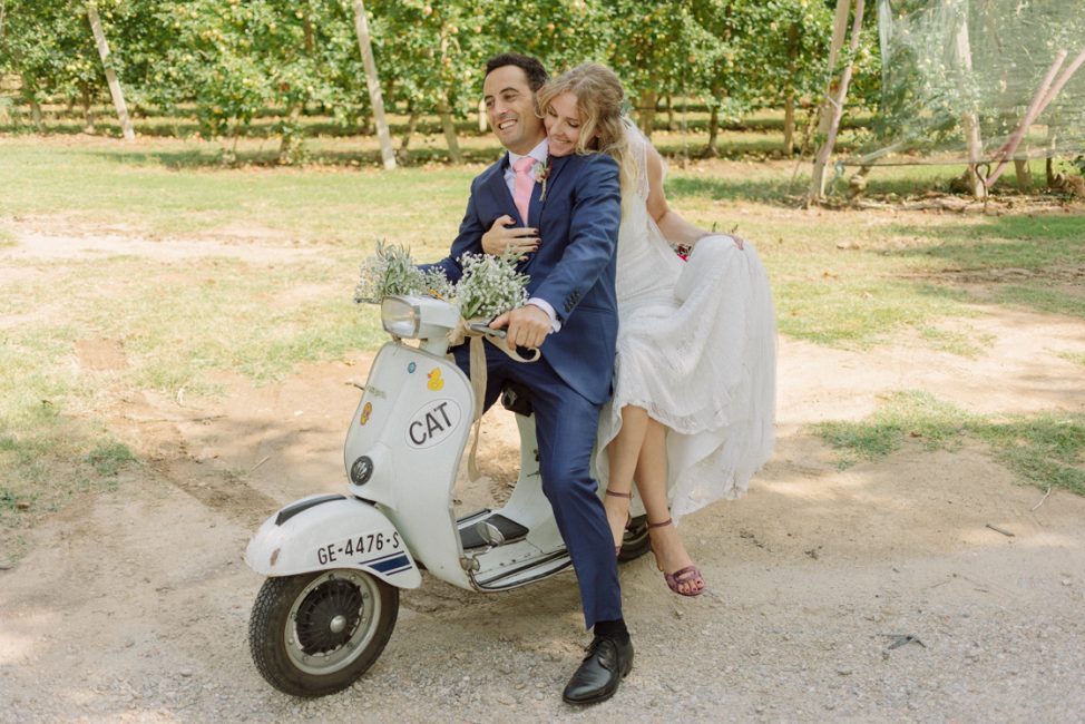 Pareja recién casada a punto de entrar en los jardines de Cortal Gran montados en una moto clasica